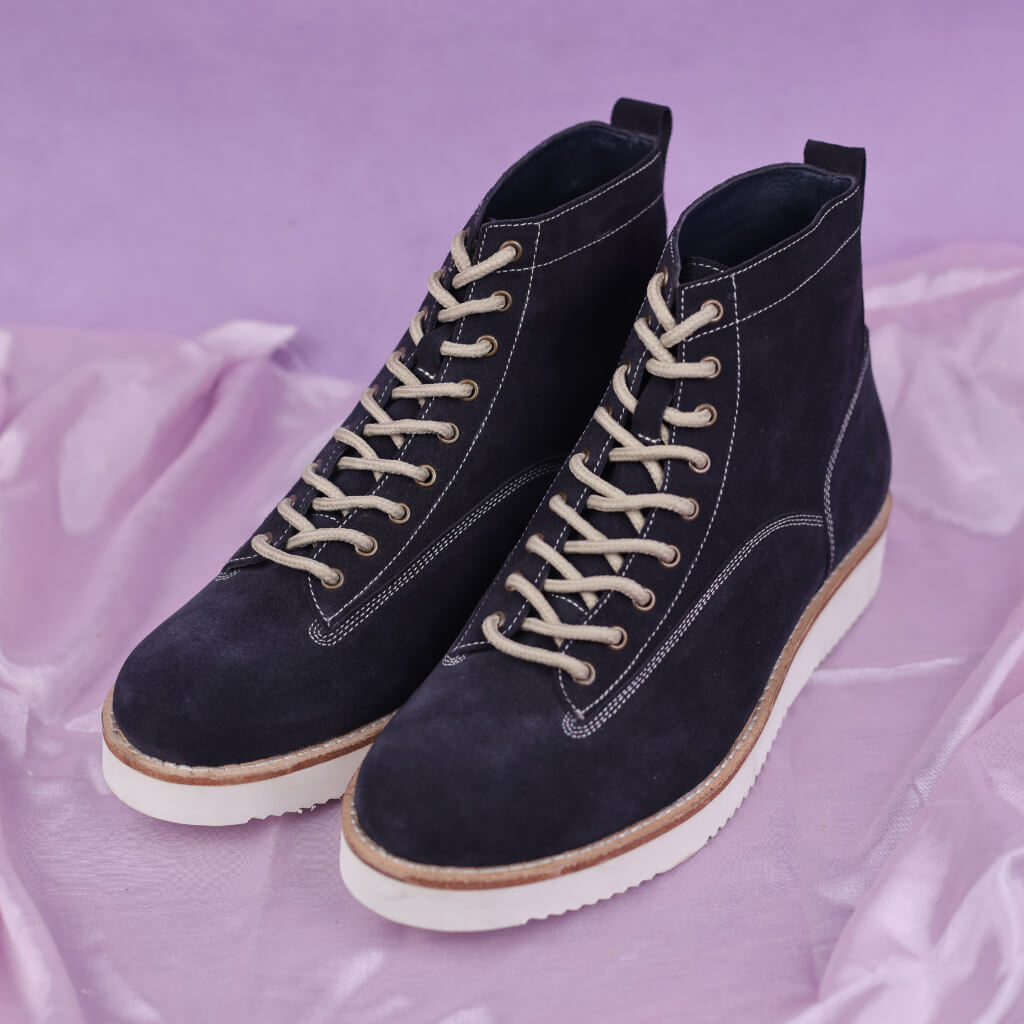 A pair of Azure Titan chunky boots crafted from premium blue suede leather. Featuring a lace-up closure for a secure fit and a distinctive white sole for a modern touch. These boots offer a blend of contemporary flair, durability, and cushioned support for everyday wear.