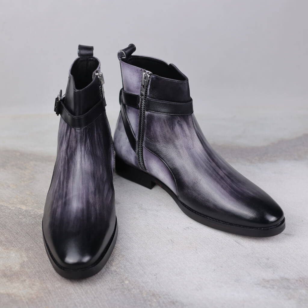 A pair of Obsidian Stride Boots crafted from premium Argentina crust leather and Italian leather, featuring a sophisticated blend of grey and black patina. Designed with Blake stitch construction for durability, these versatile boots offer comfort, style, and luxury for various occasions, from casual outings to evening events.