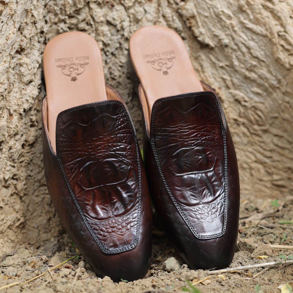 A pair of luxurious slip-on shoes featuring a croco-embossed pattern and an upper material resembling royal python scales. With a polished finish highlighting intricate textures, these shoes offer a sophisticated and exotic appearance, complemented by leather insoles for comfort and durability, perfect for formal or upscale casual wear.