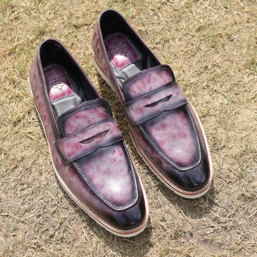 A pair of Marbled Maestro Penny Loafers crafted from premium Argentina white crust leather, featuring a stunning marble patina effect. These loafers are designed with a white EVA sole, leather welt, and memory foam cushioning for style and lasting comfort, ideal for both casual and formal occasions.
