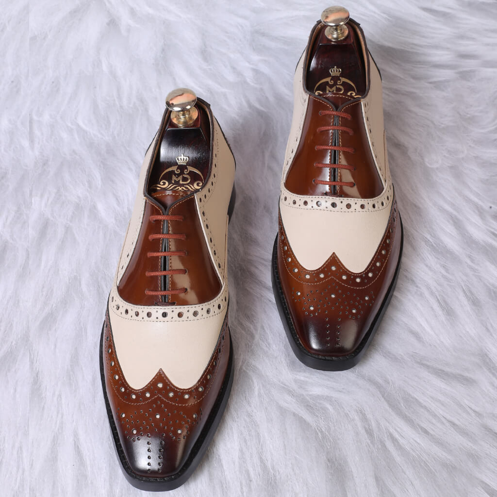 "Brown and white mirror-glossed spectator wingtip Oxfords with a two-tone design, classic wingtip detailing, and a high-shine finish for a sophisticated look."