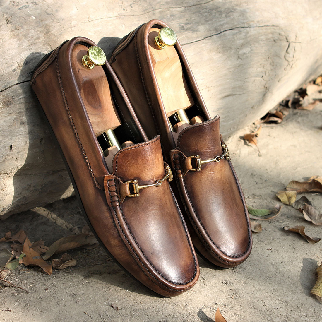 Men’s brown leather horsebit loafers with metal buckle and slip-on design