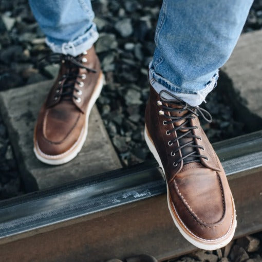 Sundown Trail Tobacco Moc Toe Boots featuring hand-stitched moc toe, smoky tobacco-hued leather, Vibram sole for traction, cork midsole for comfort, polished metallic eyelets, and sturdy laces.